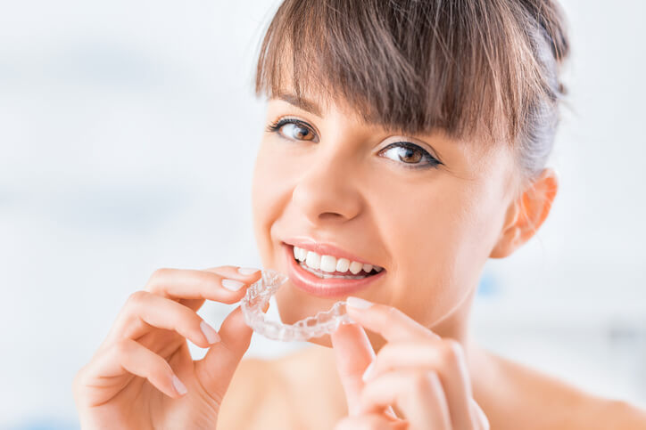 young woman using Invisalign clear aligner with Beautiful smile and white teeth